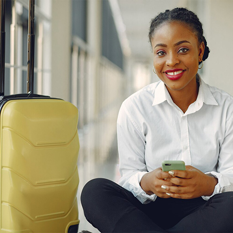 A traveller waiting with her luggage in an airport corridor