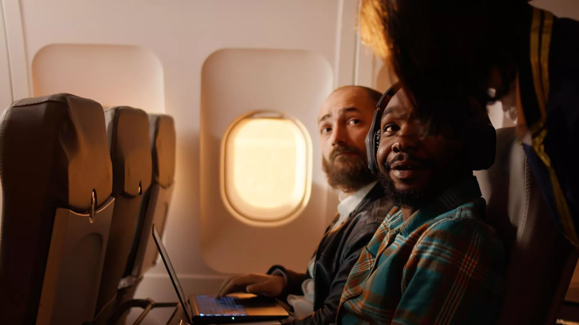 Passengers settled in an airline cabin in warm evening light